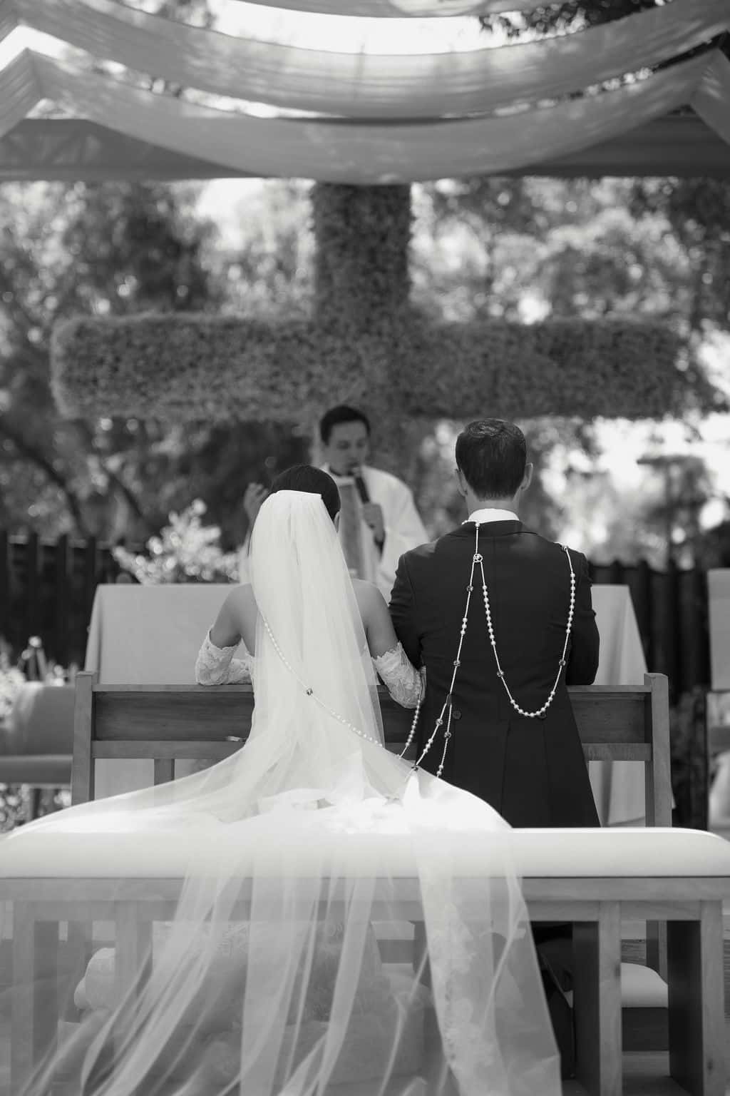 Bride and groom before the altar with wedding lasso in the garden